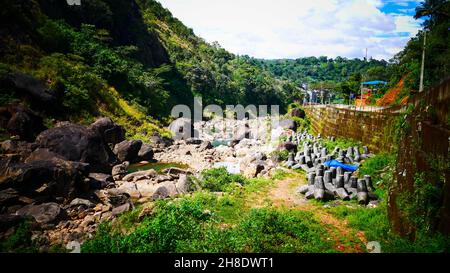 Fiume secco con ciottoli e pietre e cespugli di rotolamento grandi sul letto di fiume Foto Stock