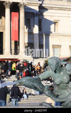 Le fontane su Trafalgar Square con il mercato di Natale fuori dalla National Gallery nel centro di Londra, 2021, Regno Unito Foto Stock