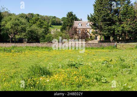 La Manor House accanto al fiume infante Windrush come scorre attraverso il villaggio Cotswold di Naunton, Gloucestershire Regno Unito Foto Stock