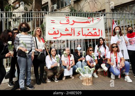 L'associazione Nun insieme alle famiglie delle vittime di Port Blast rende omaggio ai 'giudici onorari' vicino al Palazzo di Giustizia di Beirut, 29 novembre 2021. Un breve concerto e un minuto di silenzio sono stati eseguiti in memoria delle vittime. I dimostranti hanno offerto una rosa bianca a ciascuno dei 21 giudici libanesi che sostengono Tarek Bitar, il giudice responsabile dell'indagine sul porto di Beirut Blast.Tarek Bitar è stato ostacolato molte volte nella sua ricerca della verità sull'incidente, e alcuni giudici lo hanno sostenuto e lo hanno difeso contro minacce e taunts. La bandiera recita: "Una nuova giustizia pulita è Foto Stock