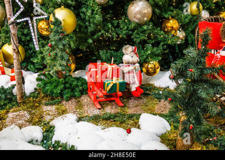 Decorazione di Natale con scatole regalo e personaggi di Natale sotto l'albero di abete Foto Stock