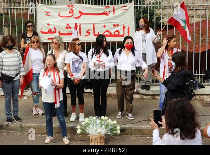 L'associazione Nun insieme alle famiglie delle vittime di Port Blast rende omaggio ai 'giudici onorari' vicino al Palazzo di Giustizia di Beirut, 29 novembre 2021. Un breve concerto e un minuto di silenzio sono stati eseguiti in memoria delle vittime. I dimostranti hanno offerto una rosa bianca a ciascuno dei 21 giudici libanesi che sostengono Tarek Bitar, il giudice responsabile dell'indagine sul porto di Beirut Blast.Tarek Bitar è stato ostacolato molte volte nella sua ricerca della verità sull'incidente, e alcuni giudici lo hanno sostenuto e lo hanno difeso contro minacce e taunts. La bandiera recita: "Una nuova giustizia pulita è Foto Stock