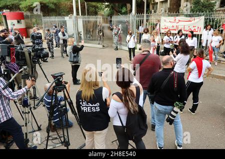 L'associazione Nun insieme alle famiglie delle vittime di Port Blast rende omaggio ai 'giudici onorari' vicino al Palazzo di Giustizia di Beirut, 29 novembre 2021. Un breve concerto e un minuto di silenzio sono stati eseguiti in memoria delle vittime. I dimostranti hanno offerto una rosa bianca a ciascuno dei 21 giudici libanesi che sostengono Tarek Bitar, il giudice responsabile dell'indagine sul porto di Beirut Blast.Tarek Bitar è stato ostacolato molte volte nella sua ricerca della verità sull'incidente, e alcuni giudici lo hanno sostenuto e lo hanno difeso contro minacce e taunts. La bandiera recita: "Una nuova giustizia pulita è Foto Stock