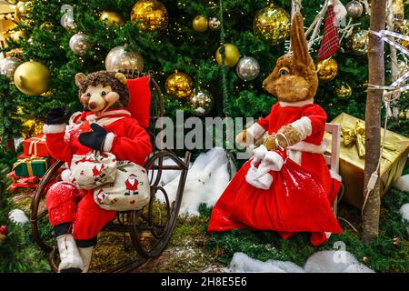 Decorazione di Natale con scatole regalo e personaggi di Natale sotto l'albero di abete Foto Stock