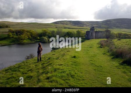 Donna in piedi da Loch Morton, Morton Castle, Thornhill, Nithsdale, Dumfries & Galloway, Scozia Foto Stock