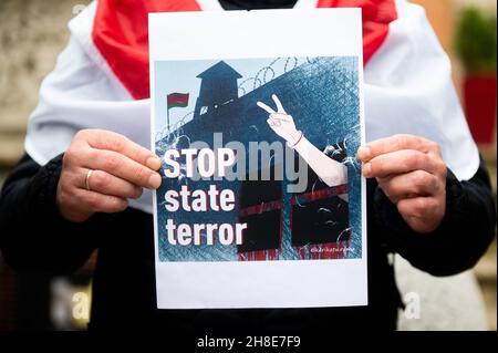 Danzica, Polonia. 28 novembre 2021. Un manifestante tiene un cartello che dice "Stop state Terror" durante la manifestazione. I manifestanti si sono riuniti al Long Market di Gdansk per esprimere la propria opposizione al regime di Alexander Lukashenko in Bielorussia, per esprimere solidarietà ai prigionieri politici e per esprimere insoddisfazione per la situazione migratoria al confine tra Polonia e Bielorussia. Credit: SOPA Images Limited/Alamy Live News Foto Stock