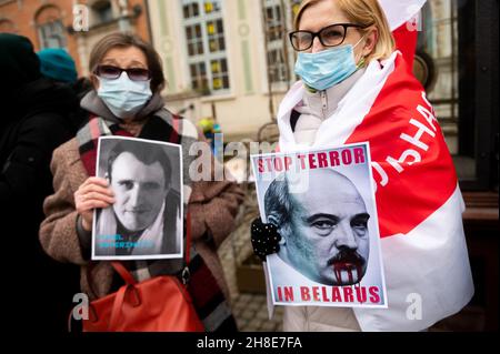 Danzica, Polonia. 28 novembre 2021. Donne viste con cartelli di prigioniere politico e "Bloody Lukashenko" durante la manifestazione. I manifestanti si sono riuniti al mercato lungo di Danzica per esprimere la loro opposizione al regime di Alexander Lukashenko in Bielorussia, per esprimere solidarietà ai prigionieri politici e per esprimere insoddisfazione per la situazione migratoria al confine tra Polonia e Bielorussia. Credit: SOPA Images Limited/Alamy Live News Foto Stock