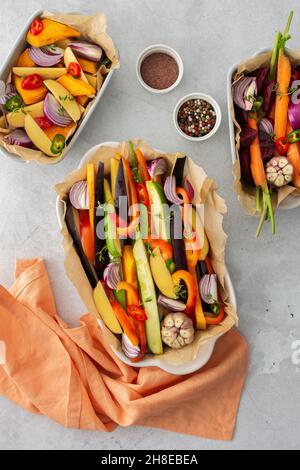 Verdure fresche tritate cucinate al forno in vari piatti di ceramica, vista dall'alto Foto Stock