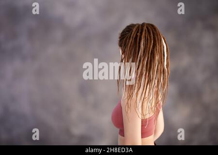 Tessitura di capelli artificiali o trecce di scatola in acconciatura di donna caucasica sportiva di 28 anni. Foto Stock