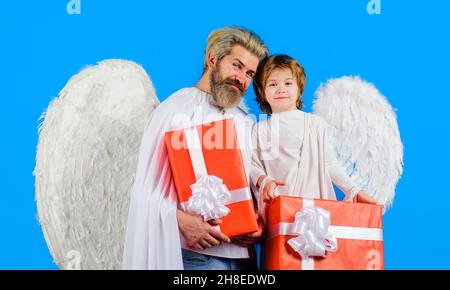 Felice padre e figlio in costume angelo con presente. Angeli di San Valentino con ali bianche e scatola regalo Foto Stock