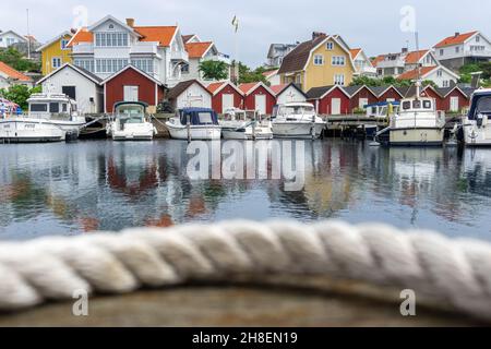 Ockero, Svezia - 10 giugno 2021: Corda sfocata in primo piano con tipico villaggio svedese sul mare Atlantico Foto Stock