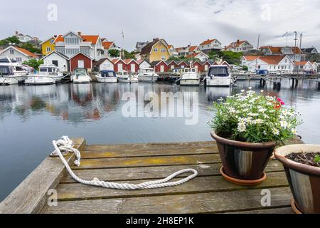 Ockero, Svezia - 10 giugno 2021: Un molo al chanel sul lato opposto del tipico villaggio svedese con case colorate Foto Stock