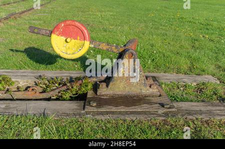 Vadstena, Svezia - 23 maggio 2021: Vecchio commutatore ferroviario su binari abbandonati circondati da erba Foto Stock