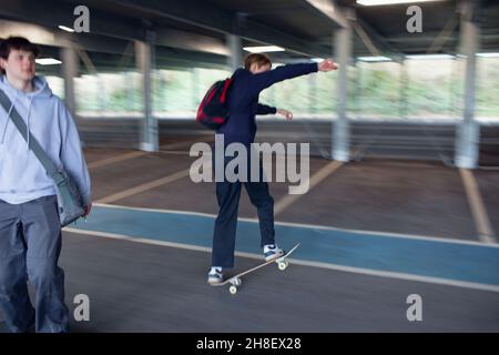 Skateboard ragazzi adolescenti nel parcheggio Foto Stock