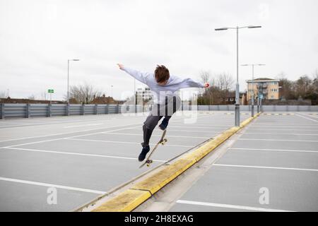 Ragazzi adolescenti con skateboard nel parcheggio Foto Stock