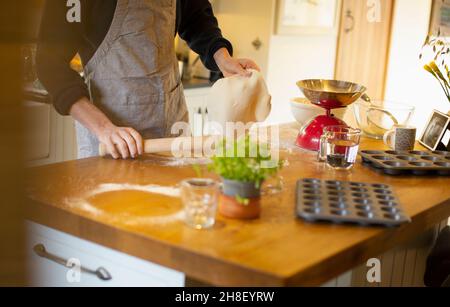 Uomo che fa pasta di pane fresco sul banco della cucina Foto Stock