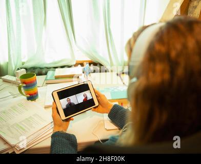 Videoconferenza donna con colleghi sullo schermo del tablet digitale Foto Stock