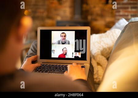 Videoconferenza uomo con i colleghi sullo schermo del laptop Foto Stock
