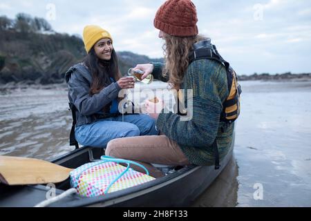 Felice giovane coppia bere vino in canoa sulla spiaggia Foto Stock