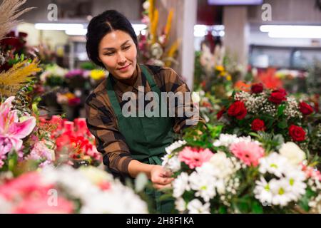 Il venditore di fiori asiatici prepara un bouquet di lusso al negozio di fiori Foto Stock