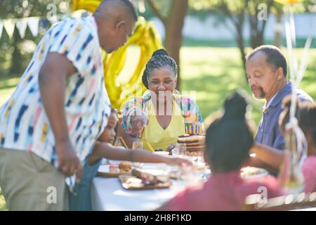 Famiglia multigenerazionale festeggia il compleanno al tavolo del patio estivo Foto Stock