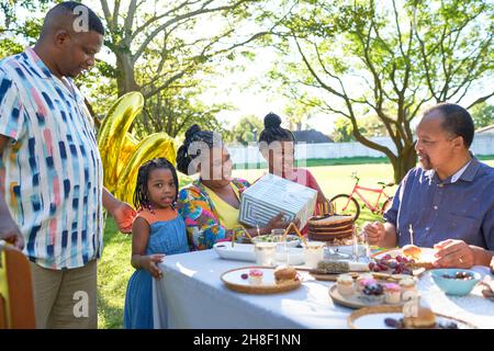 Famiglia multigenerazionale festeggia il compleanno nel cortile estivo Foto Stock