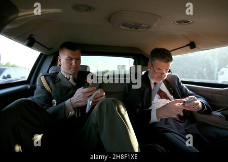 Il Vice Presidential militare degli Stati Uniti Aide Tim Stefanick, a sinistra, e consigliere al Vice Presidente, David Addington digitare sui loro cellulari blackberry mentre si guida in limousine 4 settembre 2008 a Kiev, Ucraina. Foto Stock