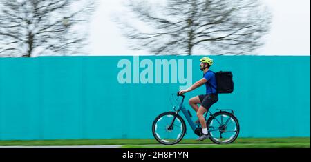 Corriere maschio che fa la consegna sulla bicicletta Foto Stock