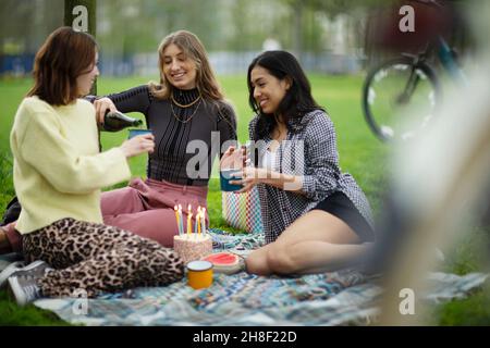 Giovani donne amiche festeggiano il compleanno nel parco Foto Stock