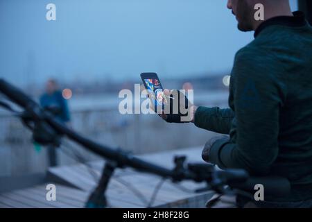 Uomo che ordina cibo da asporto con smartphone di notte Foto Stock