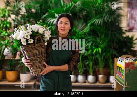 Il venditore di fiori asiatici prepara un bouquet di lusso al negozio di fiori Foto Stock