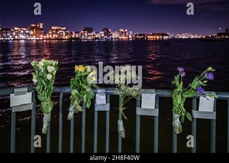 Londra, Regno Unito. 30 Nov 2021. Tributi floreali con messaggi sono lasciati dal Tamigi a Greenwich. Mercoledì 24 novembre ventisette persone - 17 uomini, sette donne, due ragazzi adolescenti e una ragazza - hanno perso la vita nei pressi di Calais cercando di attraversare la Manica con una barca gonfiabile alla ricerca di una vita migliore. L'Organizzazione Internazionale per le Migrazioni (IOM) ha dichiarato che si trattava della più grande perdita di vite umane nel canale da quando hanno iniziato a raccogliere dati sui passaggi otto anni fa. Credit: Guy Corbishley/Alamy Live News Foto Stock