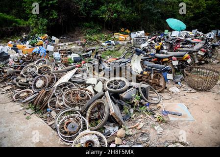 rottami di scarto con motore moto ruggine vecchia, cumulo di cerchi in metallo arrugginito vecchio nella macchina tamburo ruota veicolo spreco Foto Stock