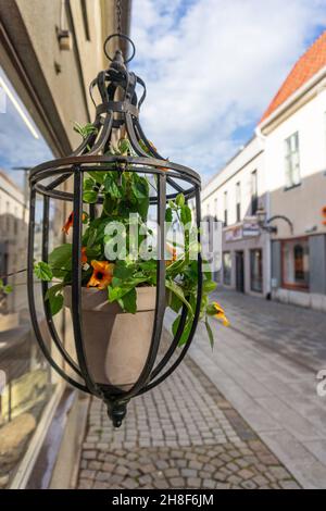 Vadstena, Svezia - 23 maggio 2021: Vaso di fiori in ferro appeso di fronte al negozio nella città medievale nel centro della Svezia Foto Stock