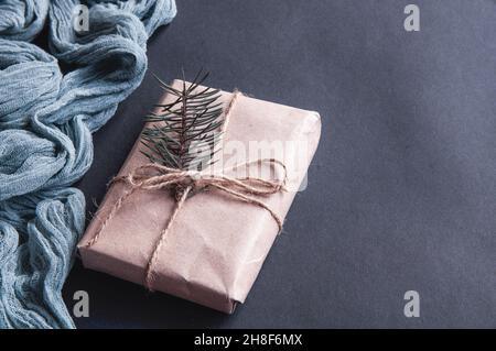 Confezione regalo accanto al runner grigio vintage su sfondo nero, composizione festiva su carta scura Foto Stock