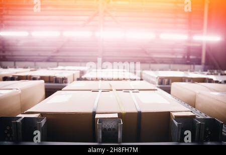 Foto di sfondo magazzino interno con cartoni di cartone al dettaglio o centro postale vista con luce solare. Foto Stock