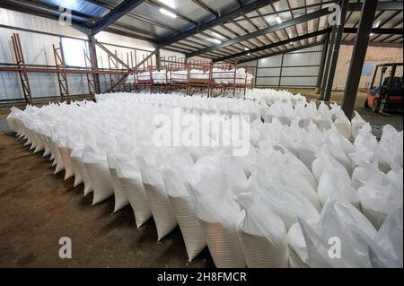 Molti sacchi bianchi in magazzino per la spedizione Foto Stock