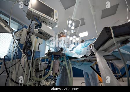 Monitoraggio del cuore del paziente in unità di terapia intensiva in sala operatoria. Foto Stock