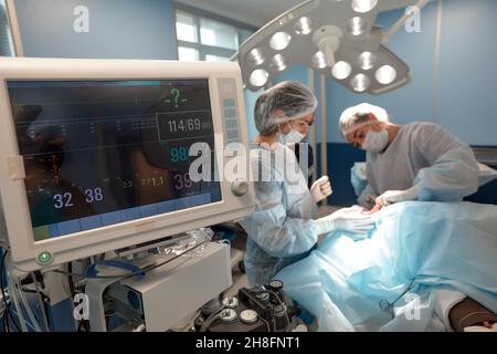 Monitoraggio del cuore del paziente in unità di terapia intensiva in sala operatoria. Foto Stock