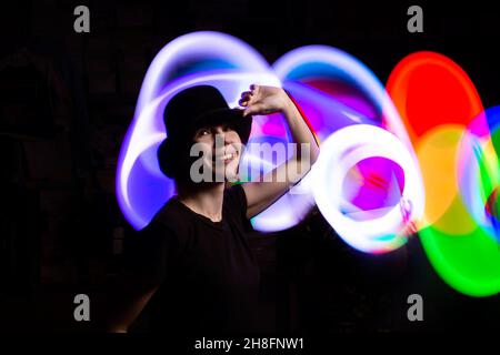 Una donna al buio in una luce multicolore. Il concetto di energia, aura. Foto Stock