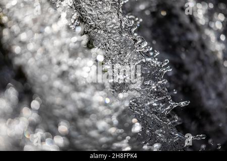 Il concetto di acqua - acqua di un fiume che scorre con riflettente la luce della sua superficie - esposizione veloce shot Foto Stock