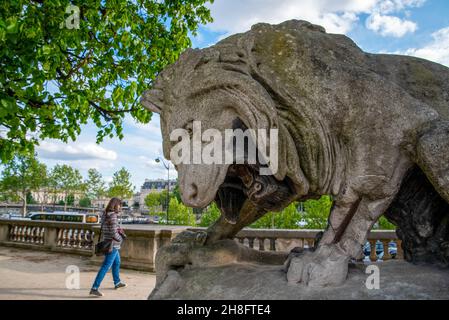 Scultura di leone gigante che rugge ad una persona che cammina vicino, il Parco del Palazzo del Louvre a Parigi, Francia Foto Stock