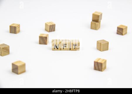 Parola NFT (token non fungibile) scritta sui cubi di legno su sfondo bianco. Token non-fungibili Concept NFT. Foto Stock