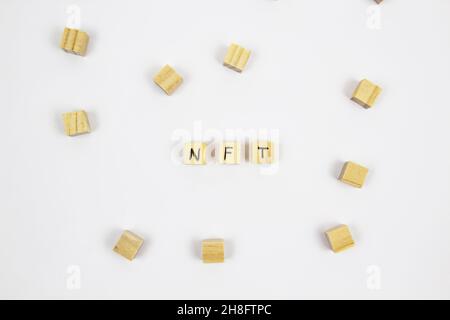 Parola NFT (token non fungibile) scritta sui cubi di legno su sfondo bianco. Token non-fungibili Concept NFT. Foto Stock