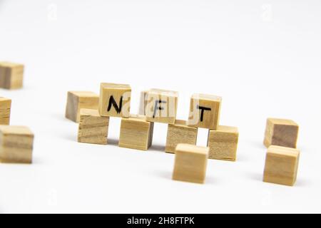 Parola NFT (token non fungibile) scritta sui cubi di legno su sfondo bianco. Token non-fungibili Concept NFT. Foto Stock