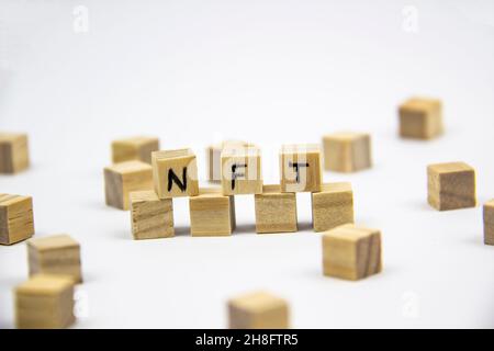 Parola NFT (token non fungibile) scritta sui cubi di legno su sfondo bianco. Token non-fungibili Concept NFT. Foto Stock