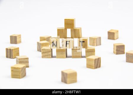 Parola NFT (token non fungibile) scritta sui cubi di legno su sfondo bianco. Token non-fungibili Concept NFT. Foto Stock