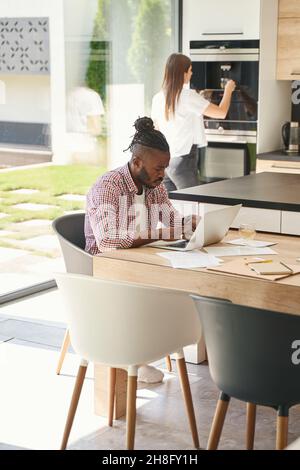 Uomo e donna seri che lavorano in cucina Foto Stock