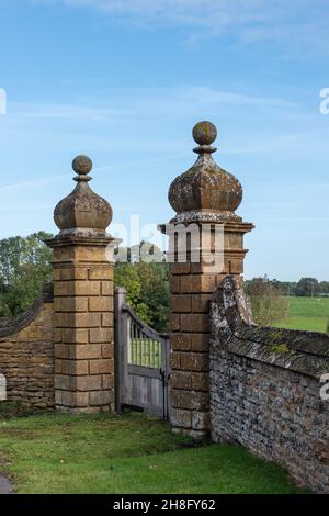 Vecchie colonne di porte in pietra nel villaggio di Ashby St Ledgers, Northamptonshire, Regno Unito Foto Stock