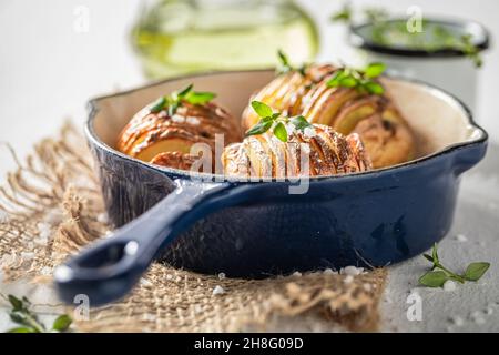 Gustoso Hasselback con erbe fresche e sale. Cucina svedese. Piatto di patate dalla Svezia. Foto Stock